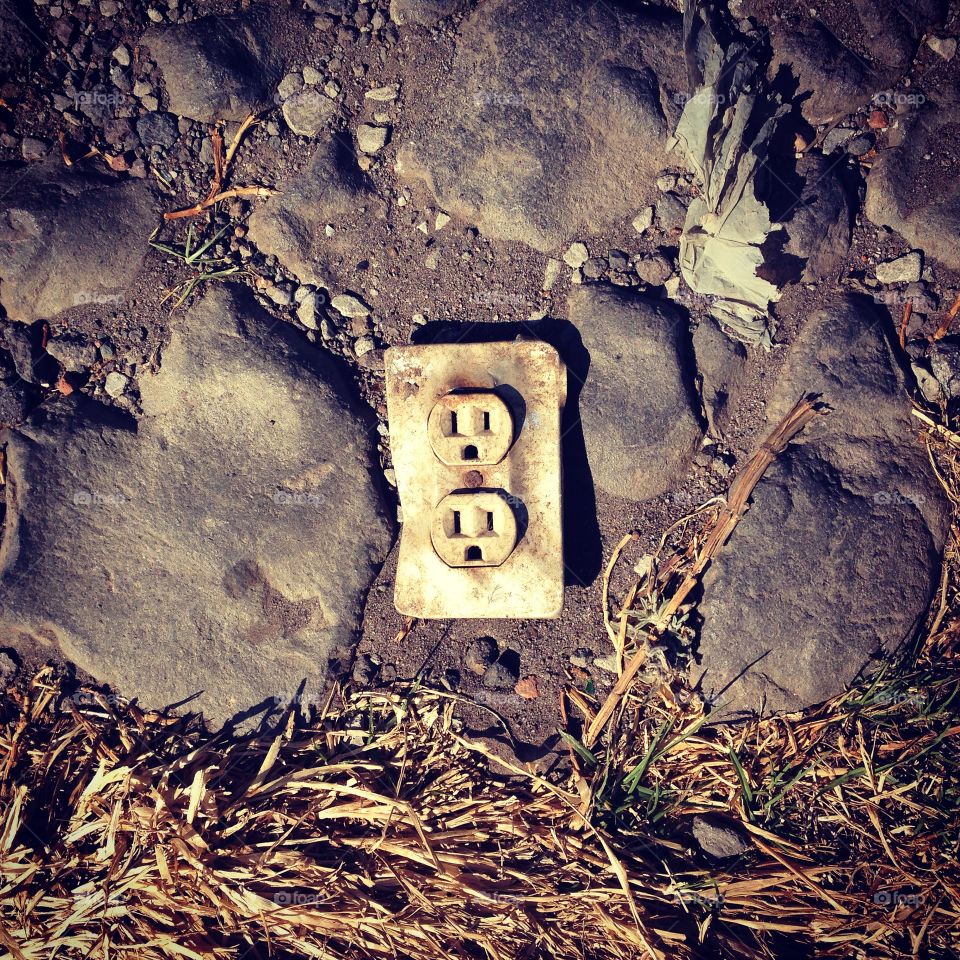 Electricity outlet dropped on a dirt and stones road