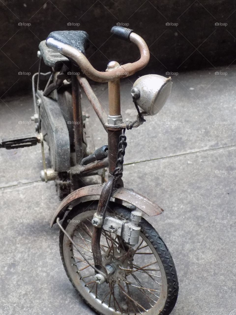 Old, rusty and broken toy bicycle