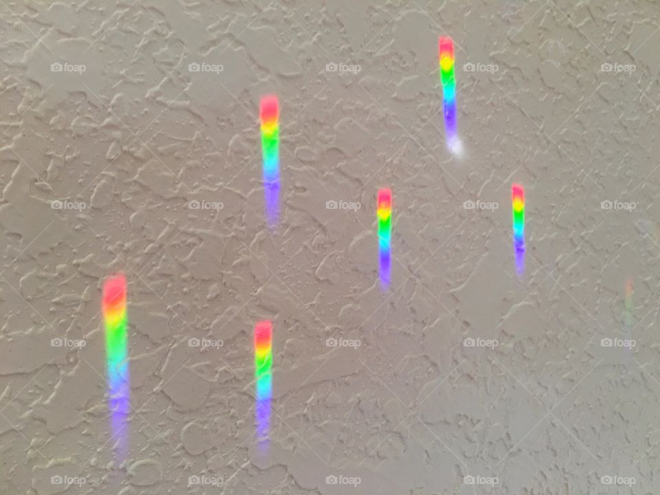 Spectrum rainbow light rays beautifully displayed on a wall.