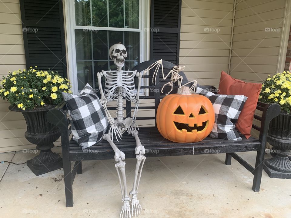 Skeleton and pumpkin bench house on the porch