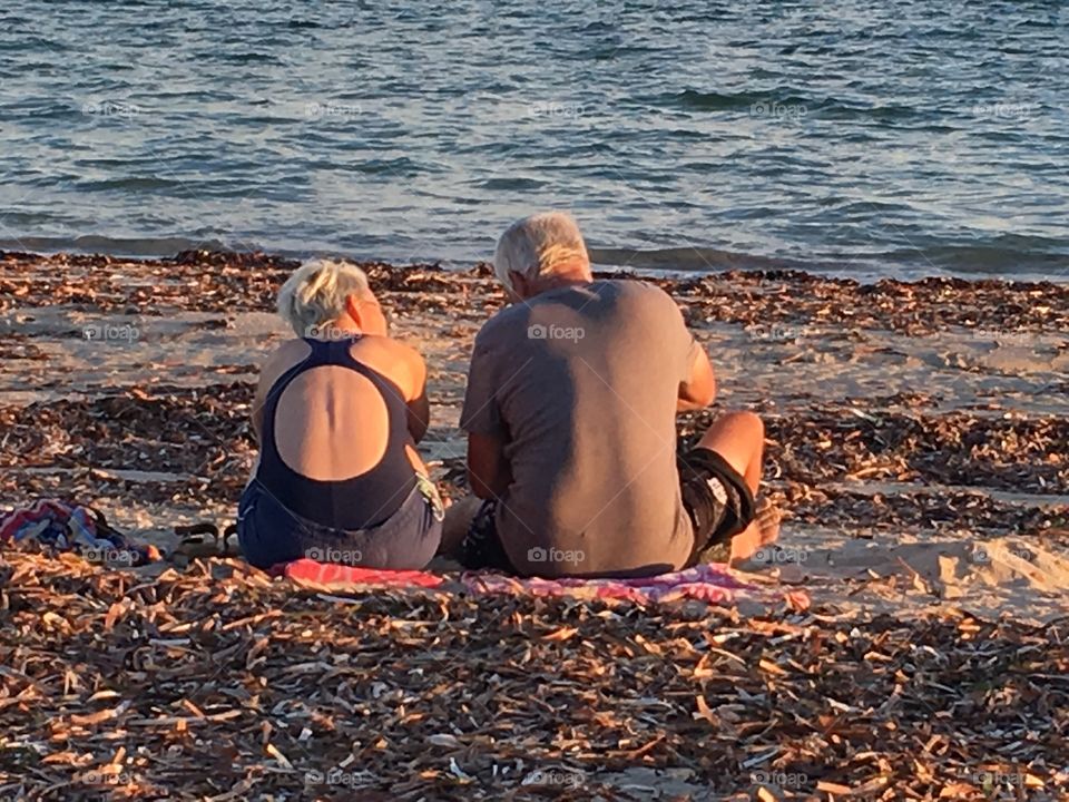 Senior couple sitting on the beach