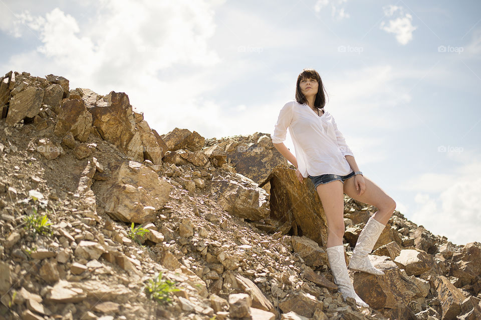 Young woman leaning on rock