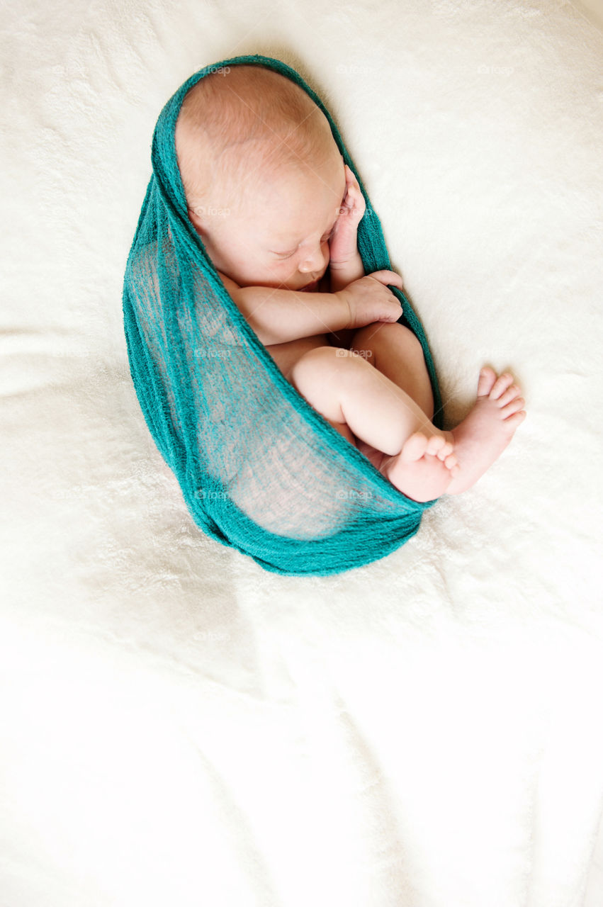 Newborn Swaddle . A newborn is wrapped in cheesecloth for a photo session.