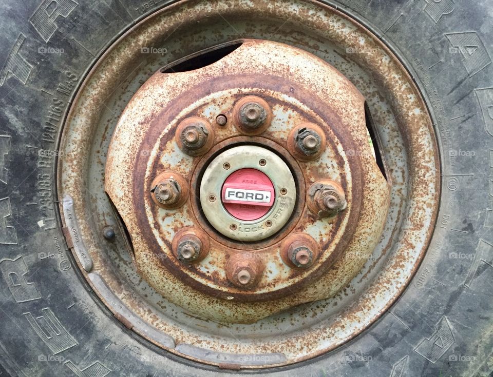 A truck tire with rusted wheel rim and bolts