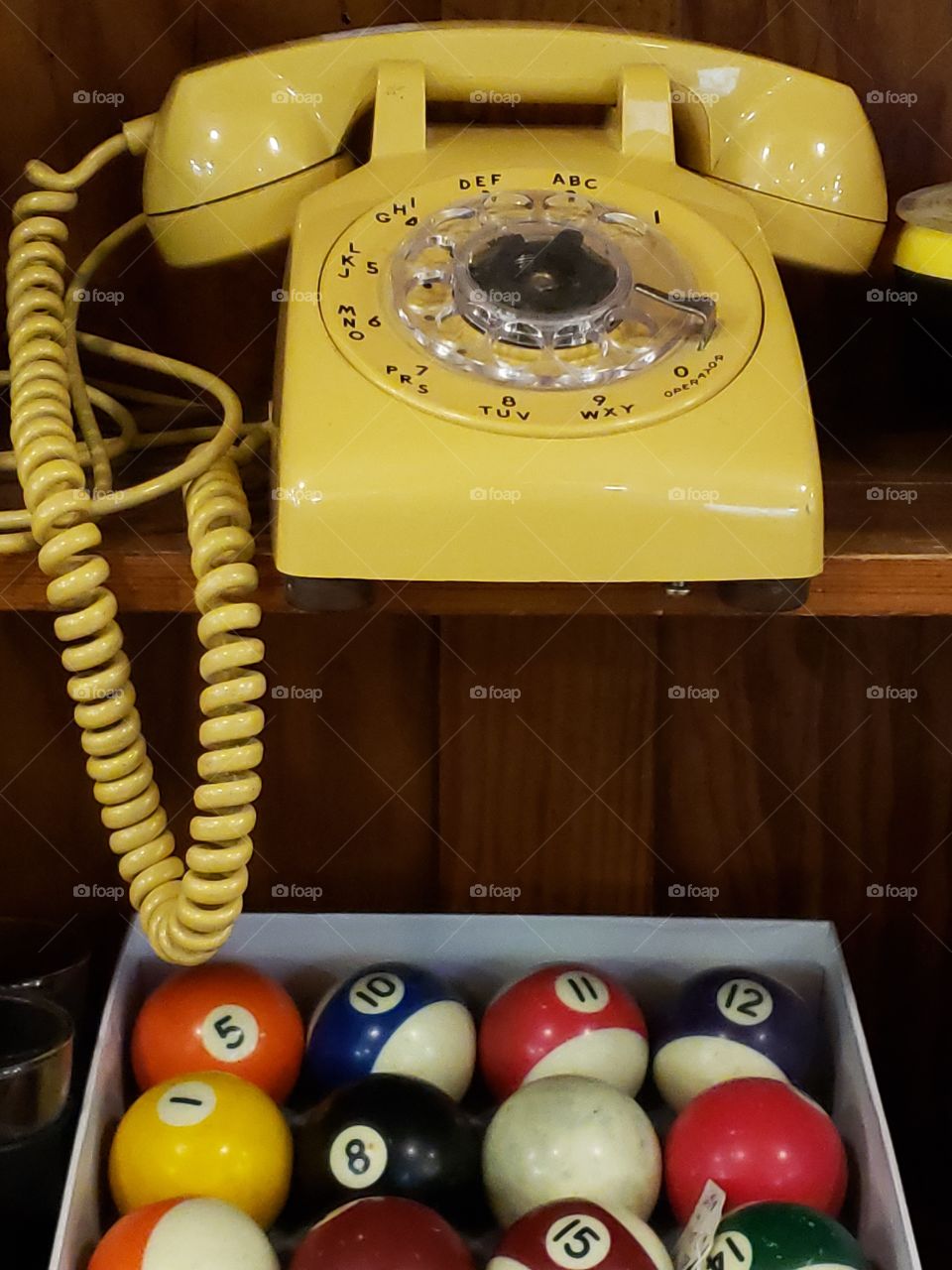 Yellow rotary phone and billiard balls