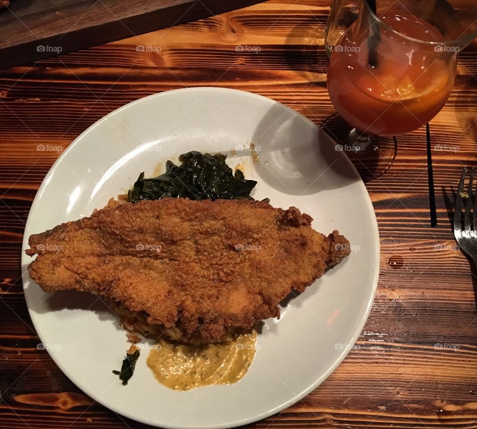 Fried catfish with jasmine rice and collard greens at a southern cooking restaurant 