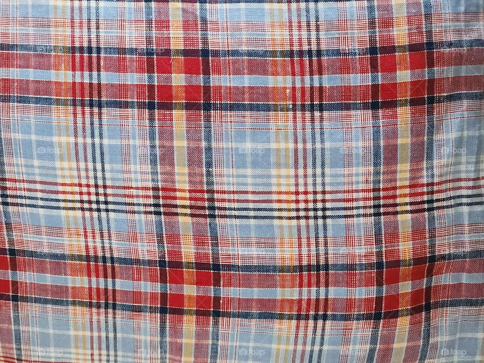 red blue white yellow black plaid pattern fabric textile close-up