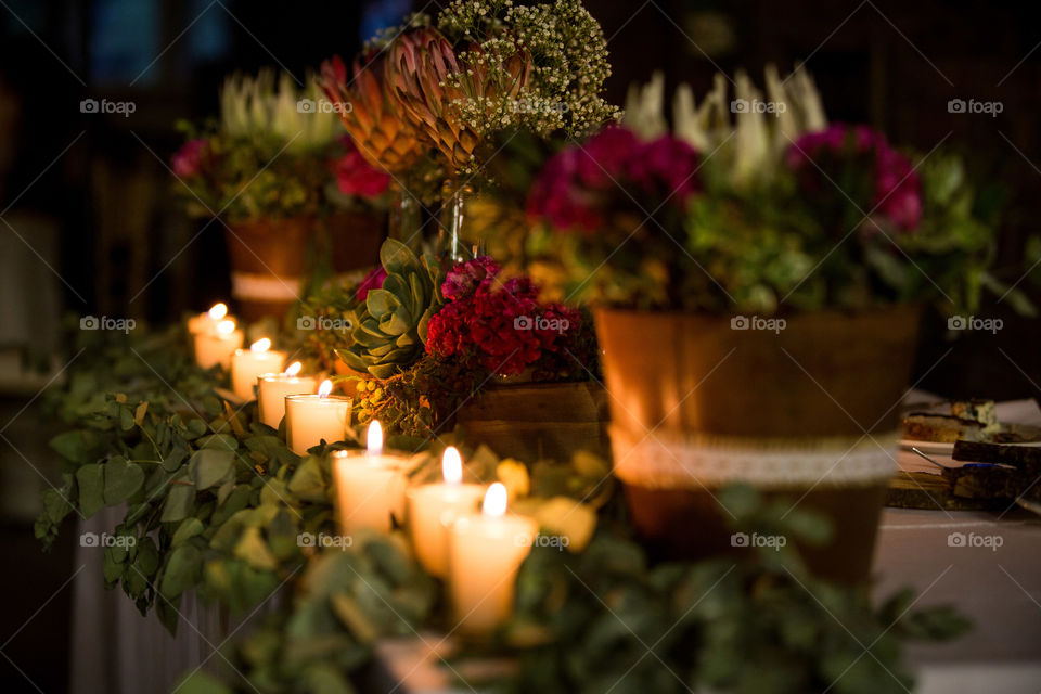 Natural vs artificial light - love the ambiance these candles create. Image of candles and table set with beautiful South African proteas and flowers