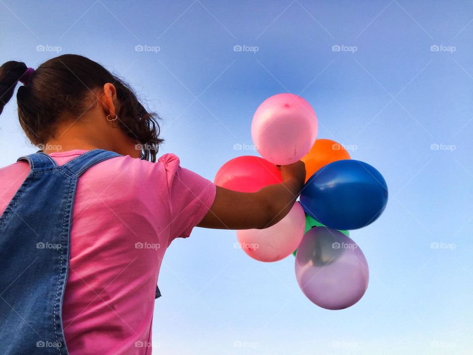 A little girl is playing with balloons 