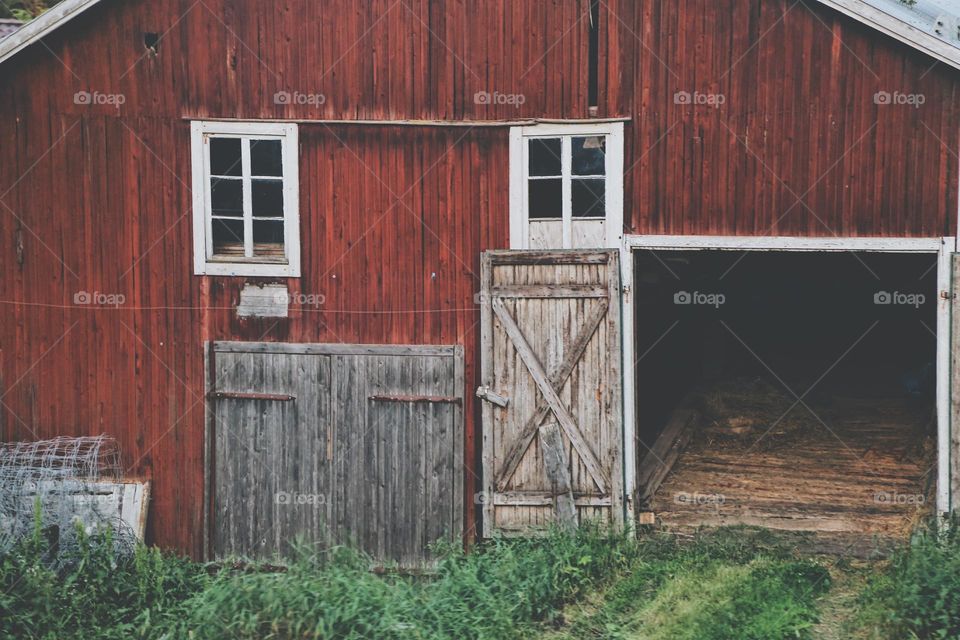 Old wooden barn facade with rustic doors and windows 