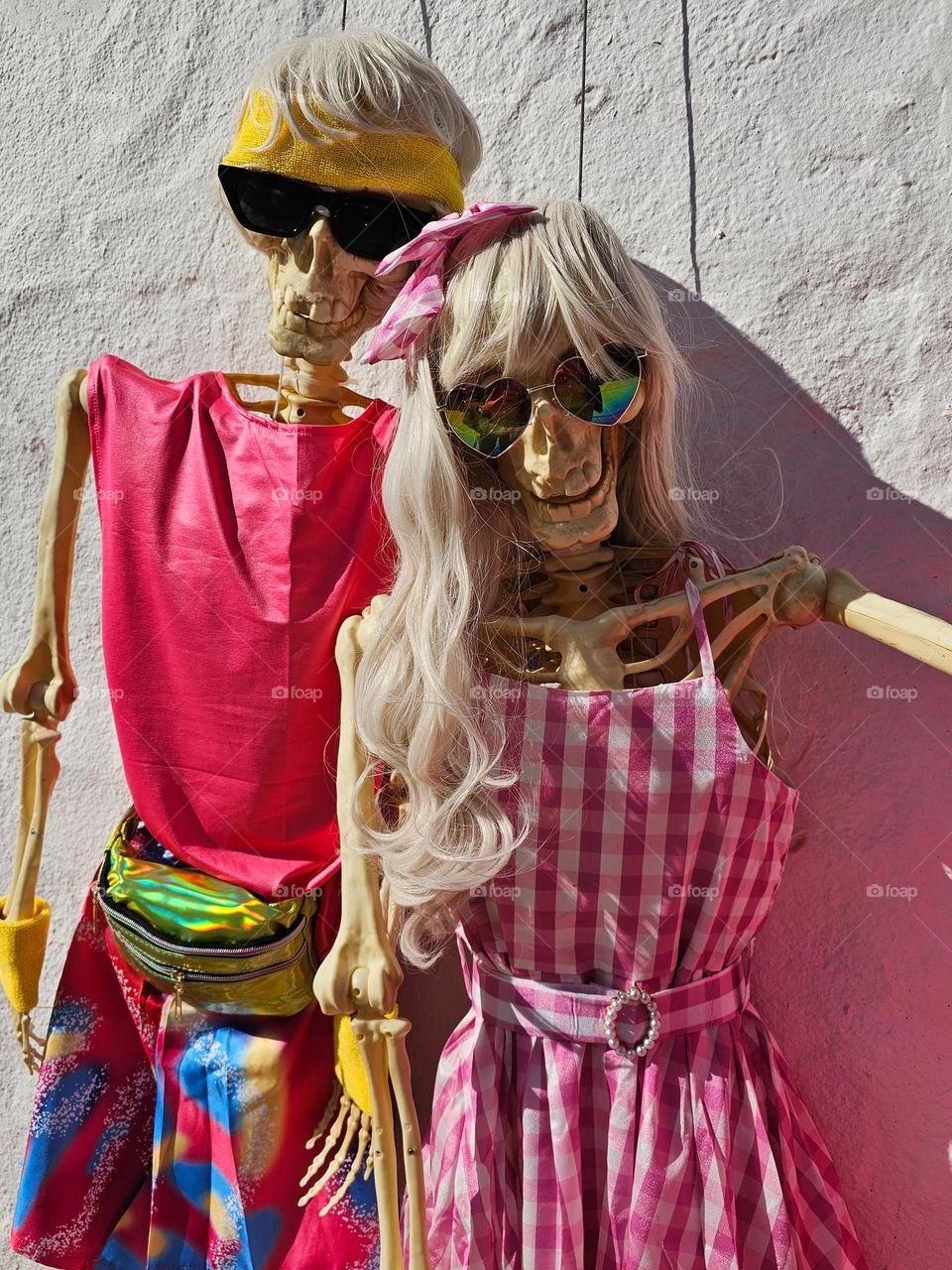 Cute and creative fall Halloween decorations in San Francisco California based on the Barbie and Ken dolls adorning a home, with vibrant pink adorned skeletons and pumpkins 