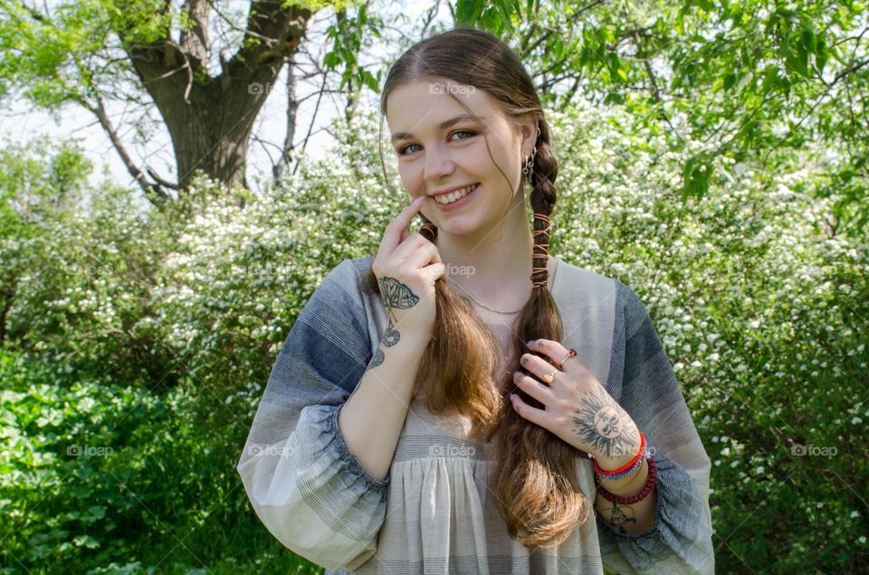 Portrait of a woman with beautiful long hair on background of flowers