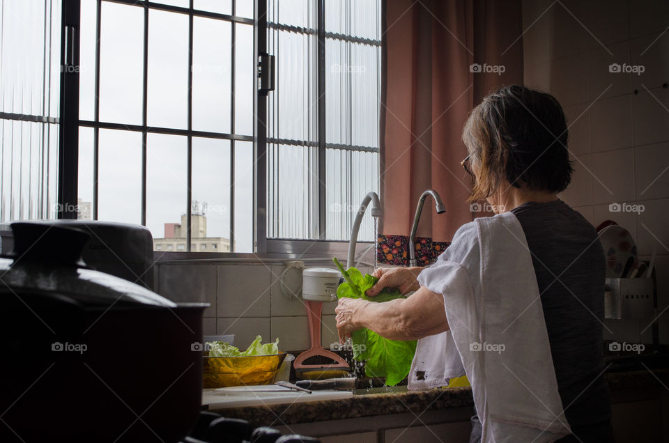 a woman sanitizing vegetables to make a delicious salad. A daily habit to take care of health.