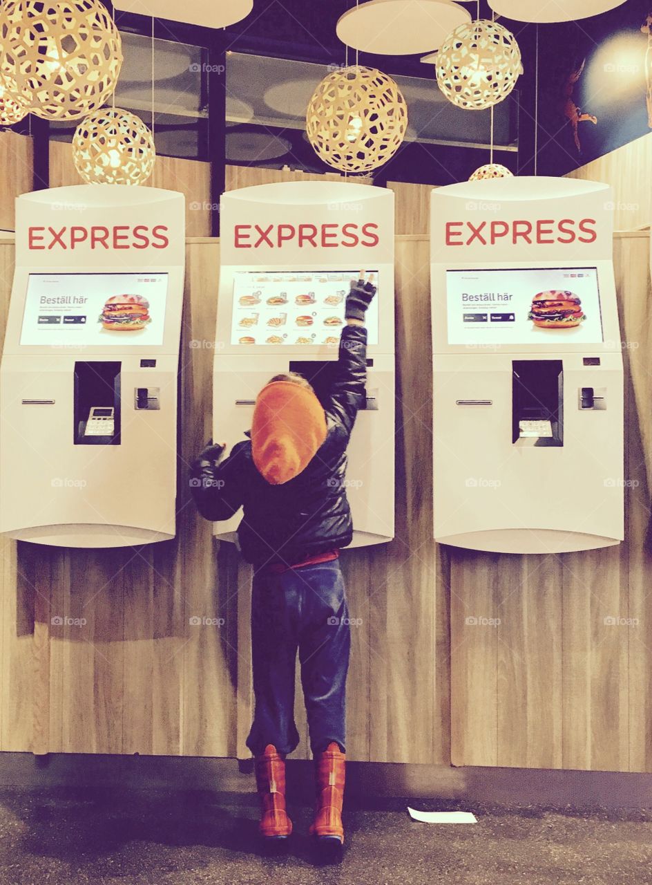 Boy ordering food in hamburger restaurant 