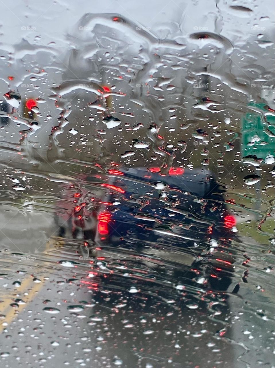 traffic viewed through rain on the windshield 