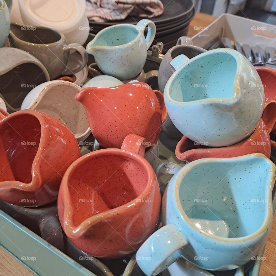 ceramic.jugs in jumble on a tray in a cafe