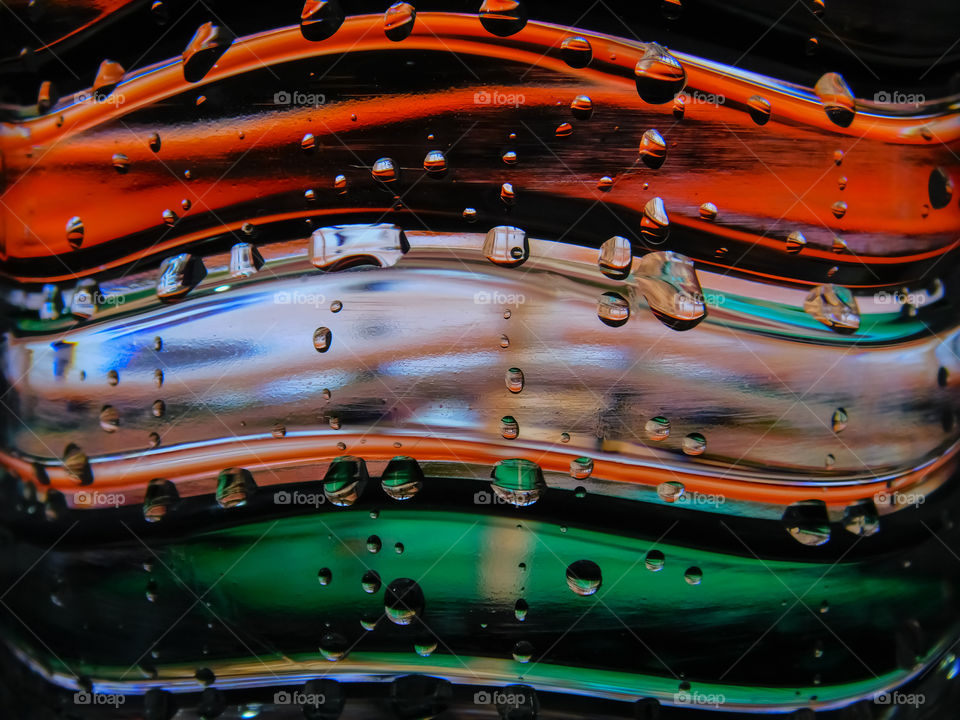 Creative macro photography of Indian flag of tri colour with the help of water bottle and small water droplets on it. It is also the reflection image.