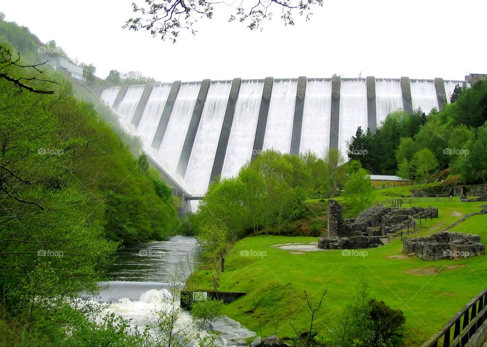 White water flowing over the Clywedog Dam in the midst of greenery