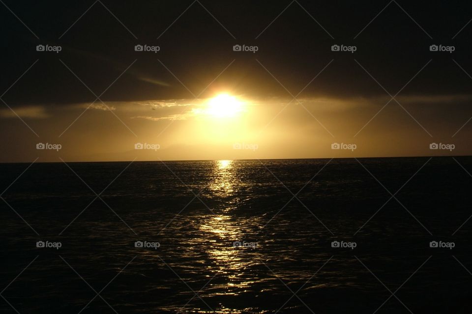 Sunset over the horizon of the Great Salt Lake under storm clouds