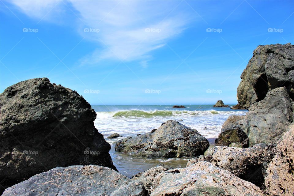 Seaside wave coming into the rocky shore