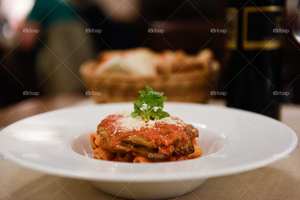 Pasta dish at the restaurant in Sicily with red wine and bread.