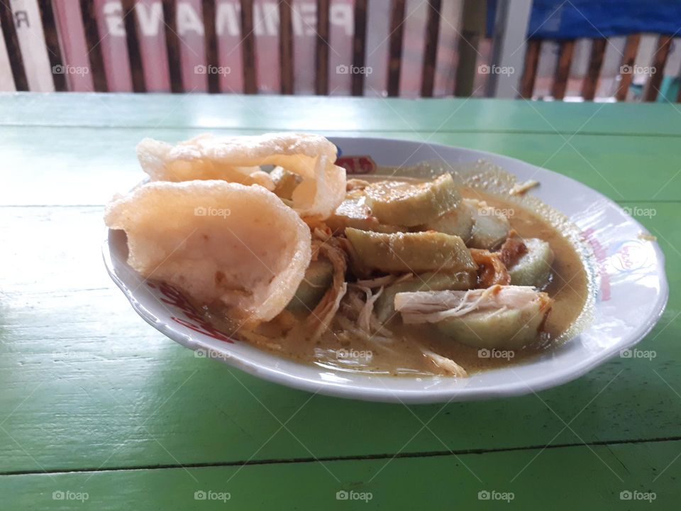 lontong opor menu served on a white plate on the dining table is suitable for breakfast