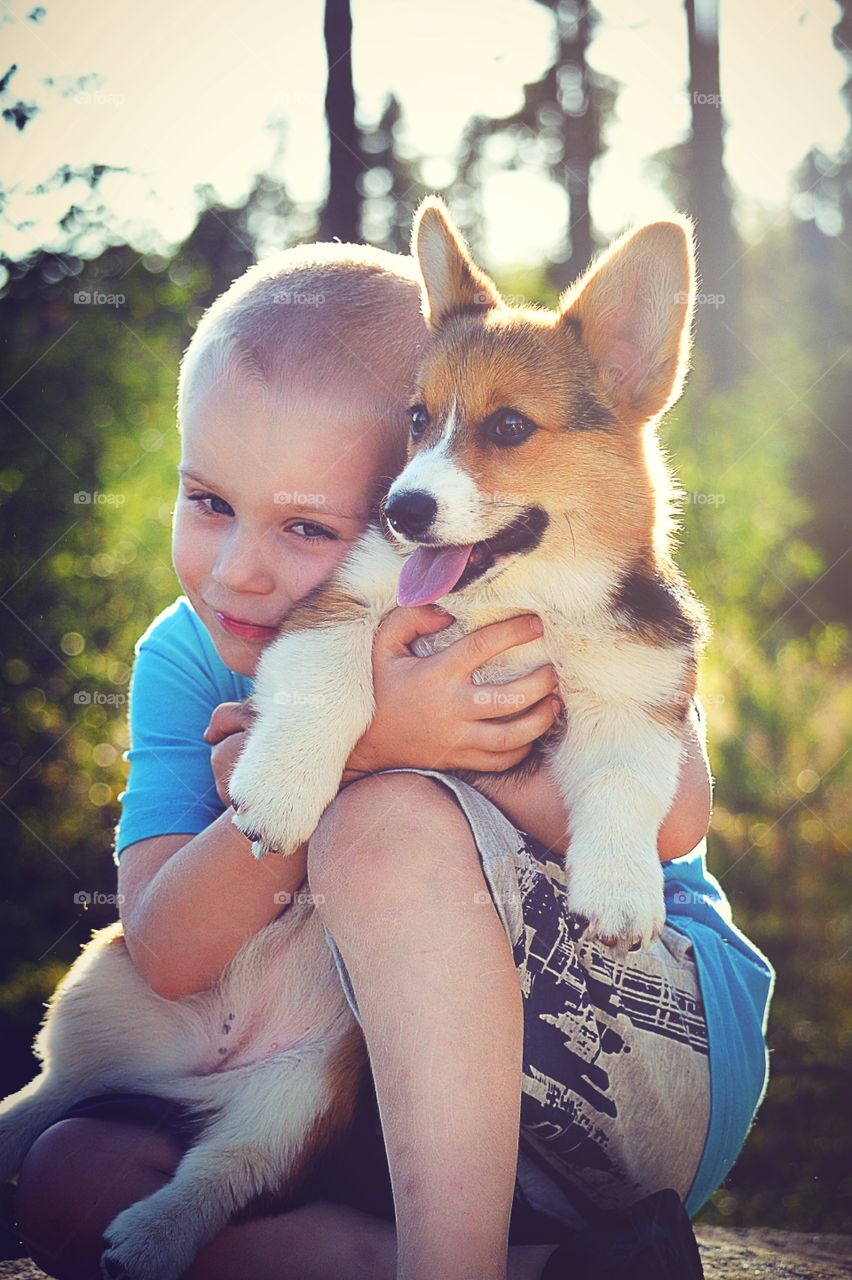 Boy and a puppy. Boy hugs a pup