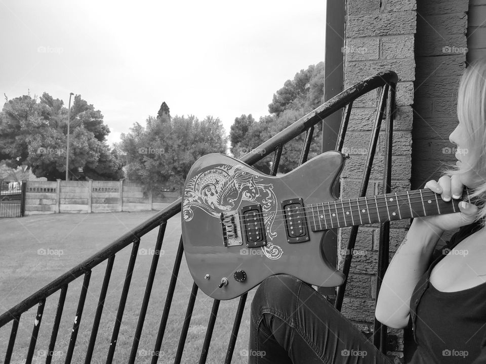 Female sitting with Electric Guitar