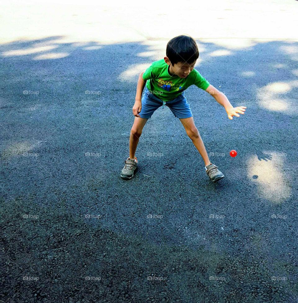Child Playing With Small Red Ball