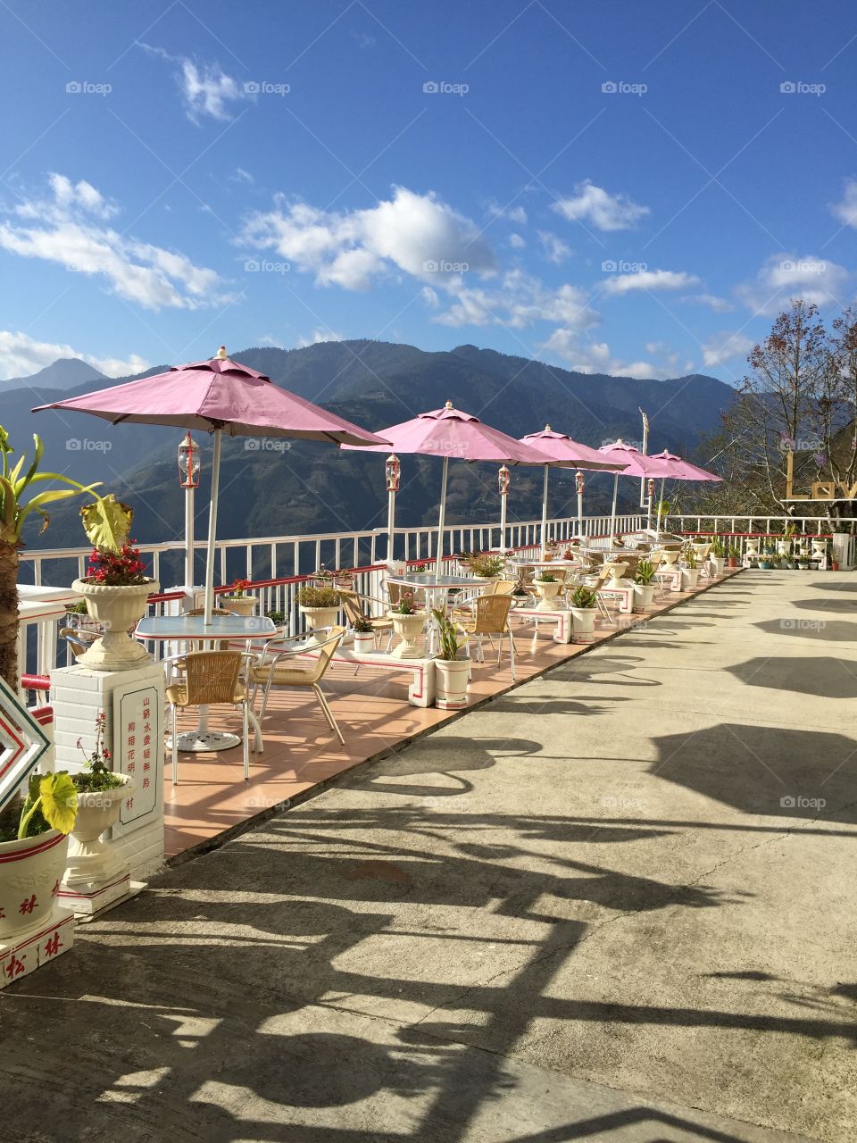 The pink-parasol seats in mountains under sunny day