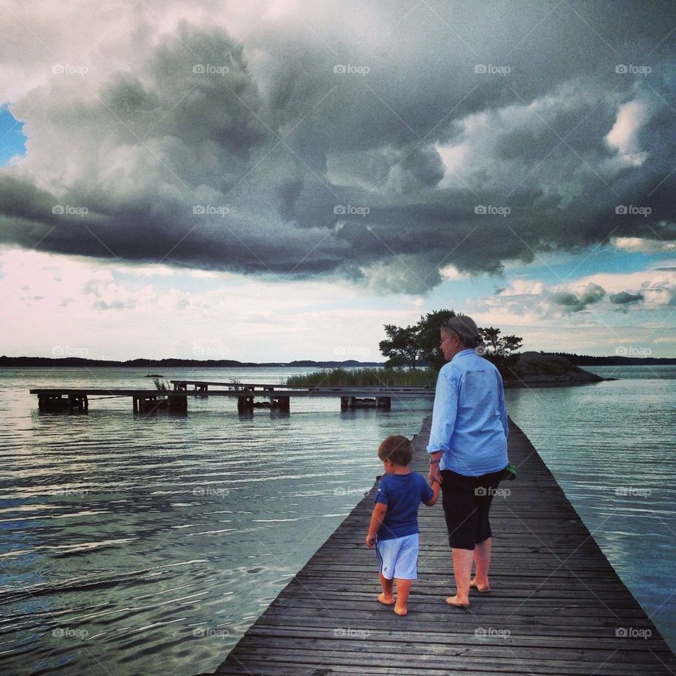 Grandma and grandson on pier on cloudy day