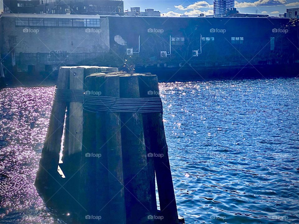 The pilings of wood blocks have to be 25 feet away from the Pulaski Bridge at Newtown Creek. This picture was taken in the evening sun in October 2021. Hypnotic Productions