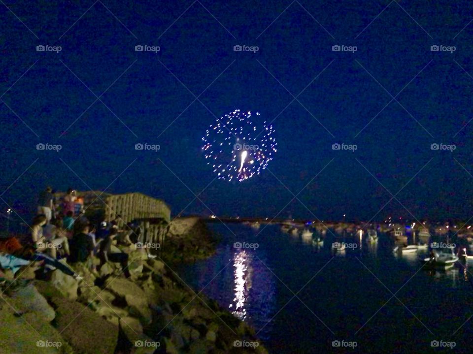 Fireworks display over the jetty and harbor on the evening of the Fourth of July 