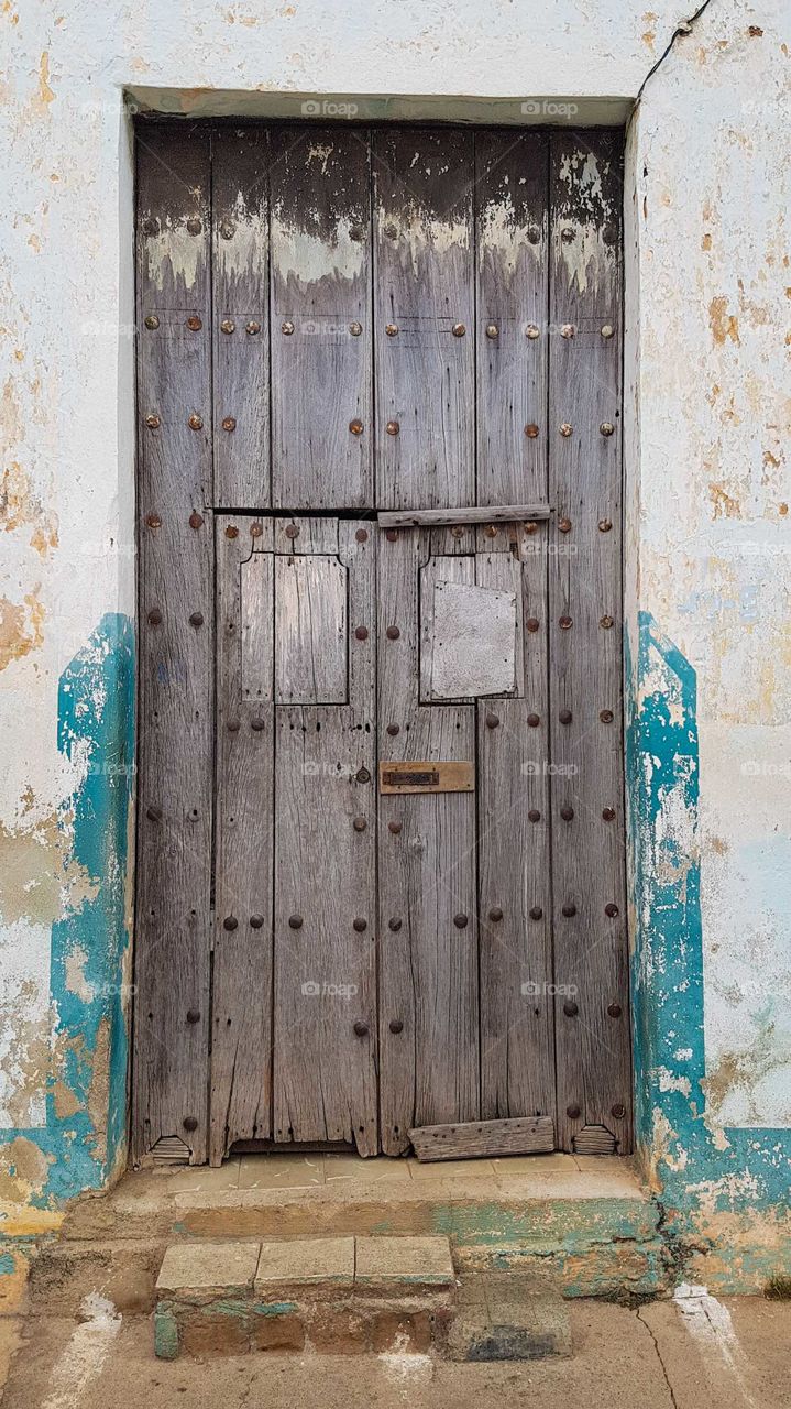 Old wooden door with lots of rusty rivets