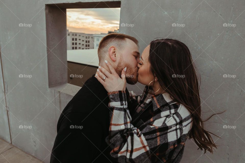 engaged couple kissing.
