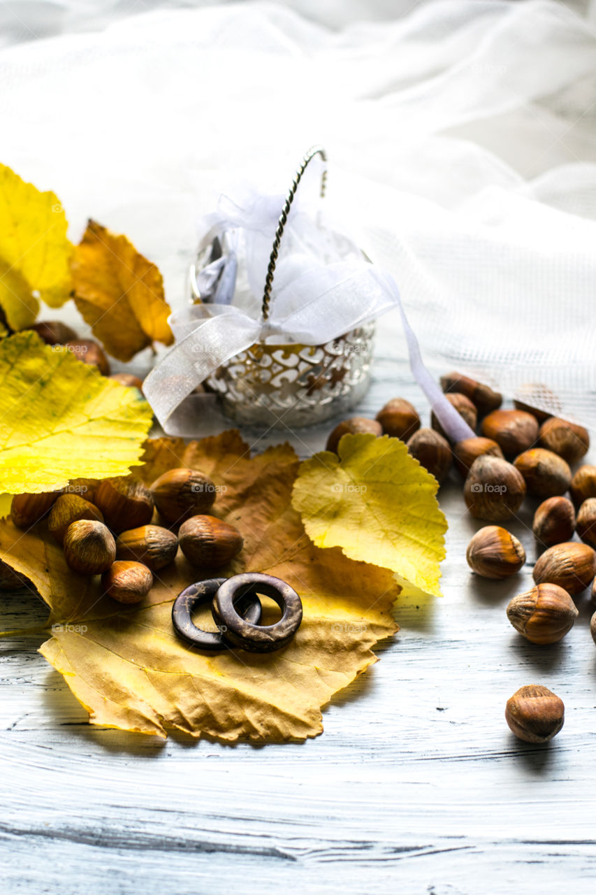 rustic, autumn wedding invitation background, leaves, nuts and wooden wedding rings