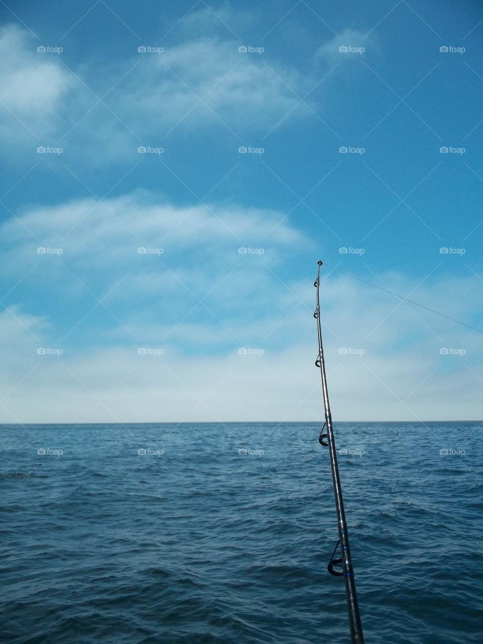 Out fishing on the Pacific Ocean, nothing but calm ocean with a lone fishing pole patiently waiting for the catch of the day