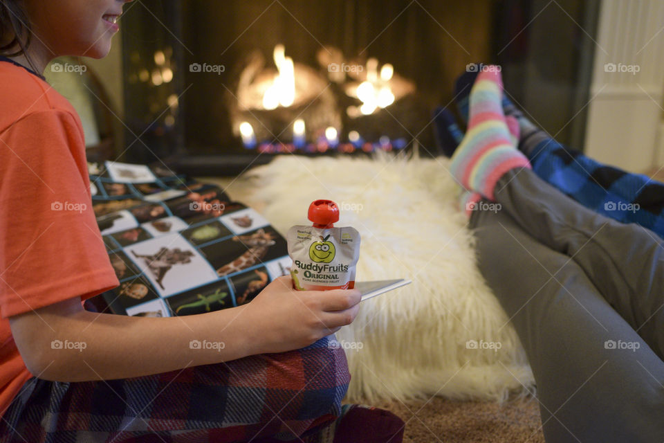 Having a Snack and Reading a Book with Family by the Fire on a Cold Winter Evening 