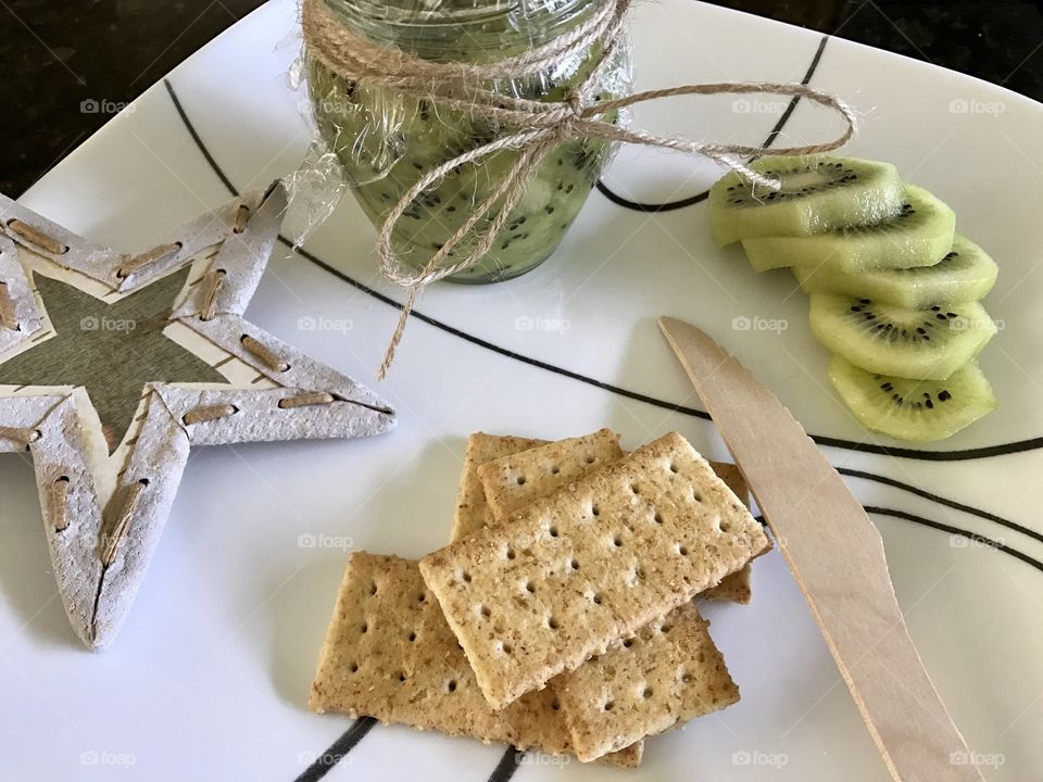 Homemade Kiwi jam and crackers on a plate 
