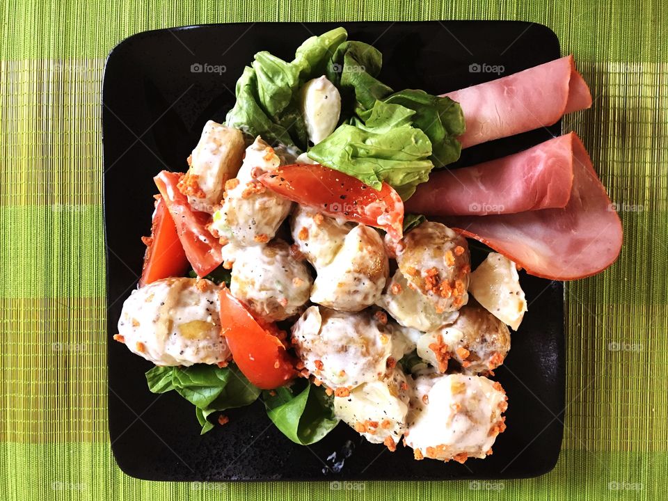 Strong colours of homemade potato salad on a contrasting background. Healthy lifestyle and stimulating food 