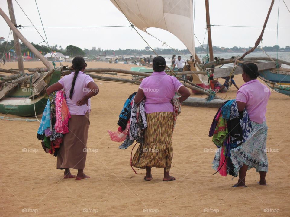 Ladies sell their sarongs on the beaches of Negombo Sri Lanka. 