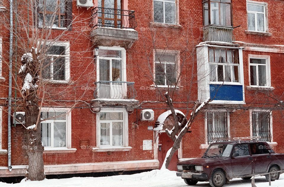 Old car parked in front of the house. Shot on film 