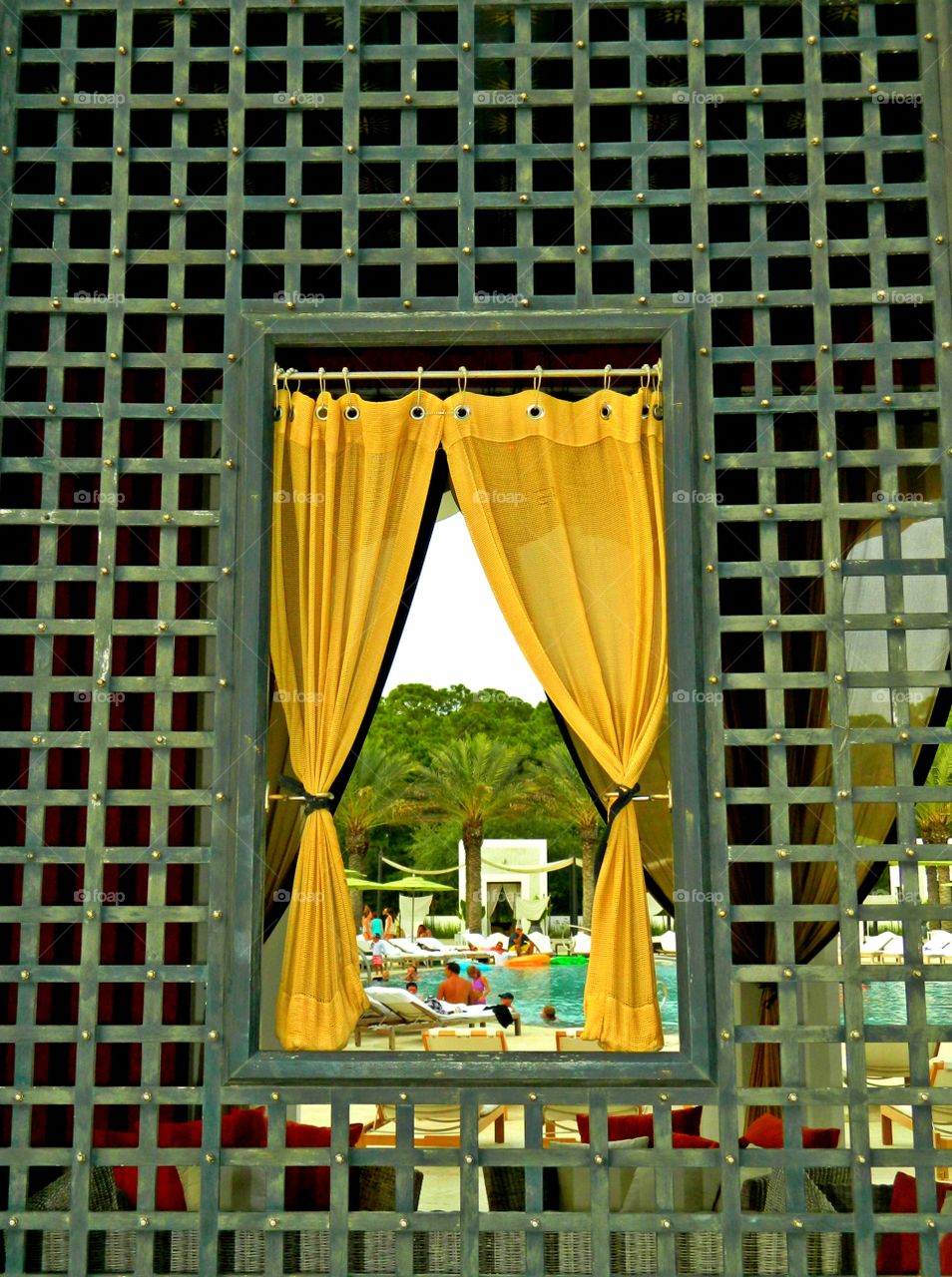 Framing the frame within the frame photo and yellow curtains draws focus to the subject in the photo by blocking other parts of the image with something in the scene