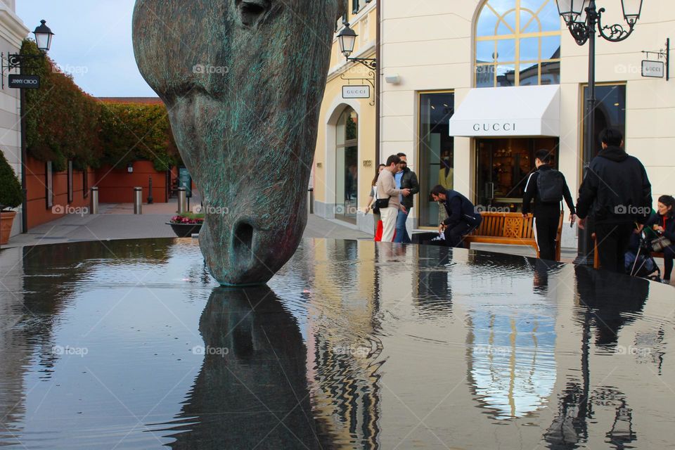 Still water horse head with  reflection, statua in the Mall of Italy.  Urban scene