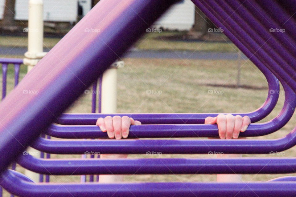 Child hang the metallic bar at playground