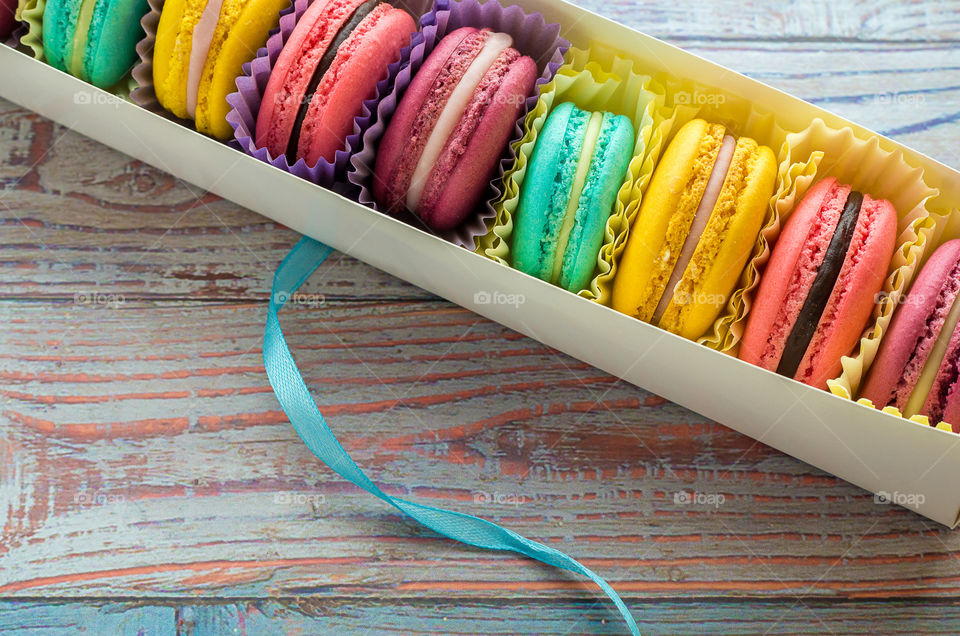 macaroons in packing on a wooden background
