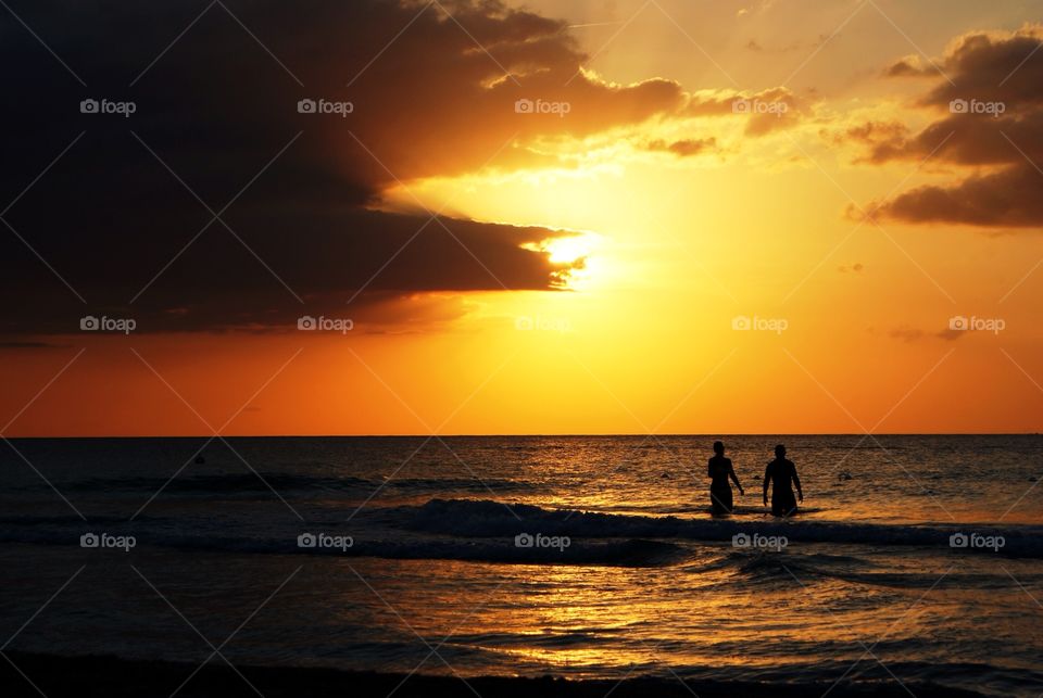 couple in the ocean ,with a sunset