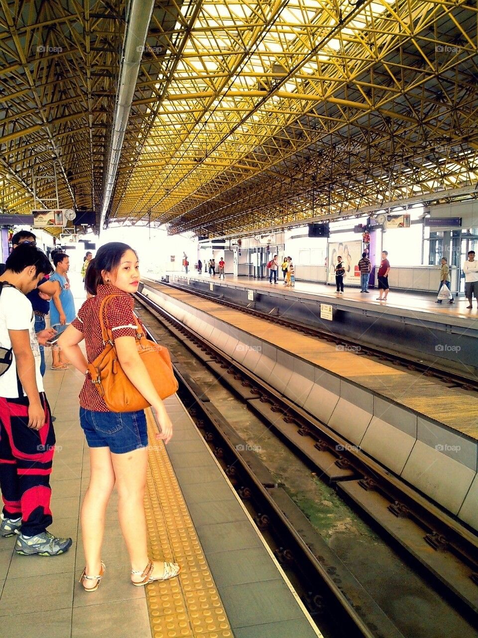 Commuters wait at a train station