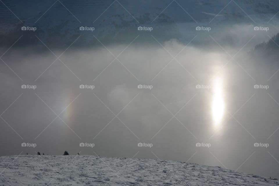 winter landscape in the mountains with fog and sun