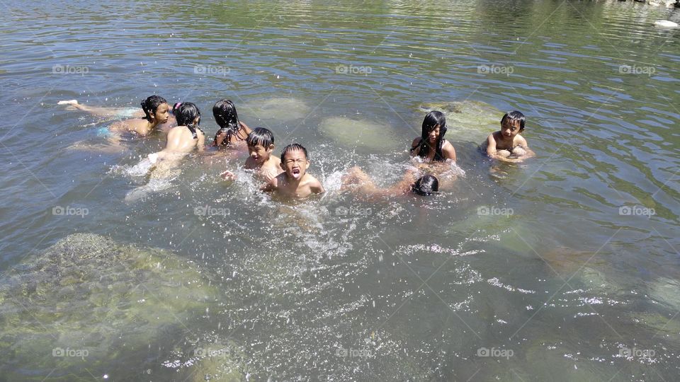 children having fun swimming in the river